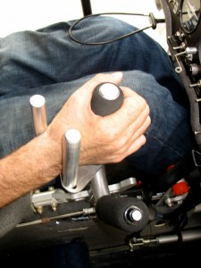 The pitch and roll is controlled with the control column on his right hand, push it forward or back to lower or raise the nose of the aircraft. Pushing the control column left or right banks the aircraft left or right.